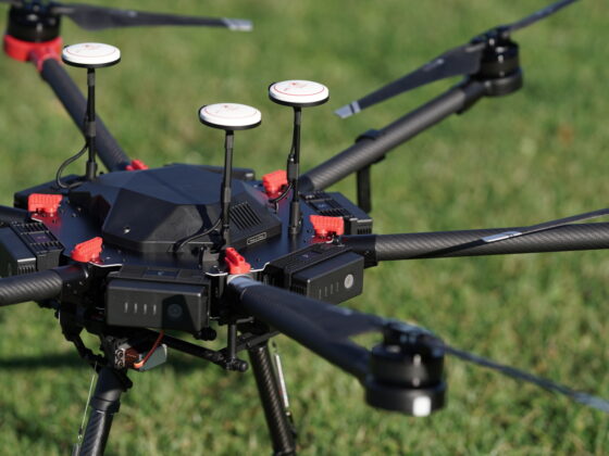closeup of a large black drone resting on a green lawn